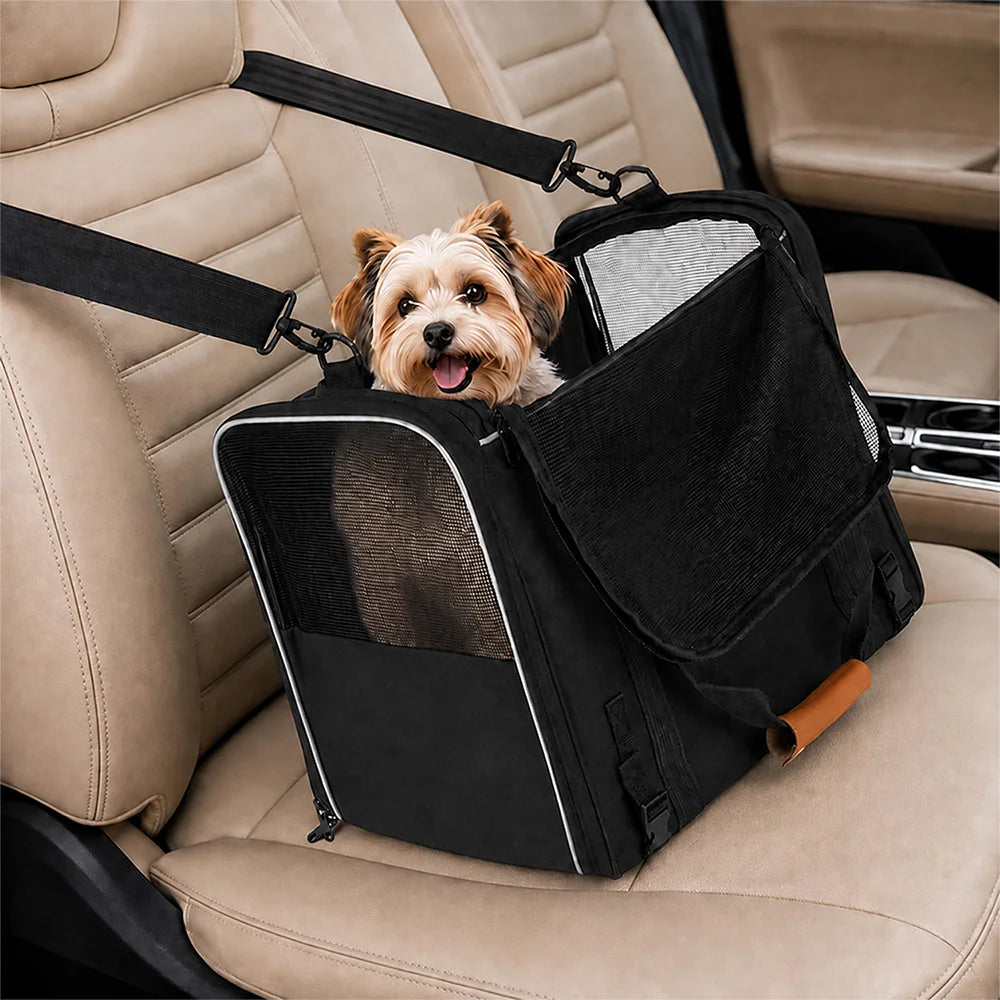 Petit chien dans un sac de transport noir ouvert sur le dessus, posé sur un siège de voiture beige et maintenu par des sangles