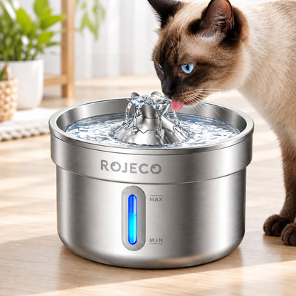 Chat siamois aux yeux bleus buvant au jet central d’une fontaine à eau en inox, avec fenêtre lumineuse et repères de niveau MIN et MAX.