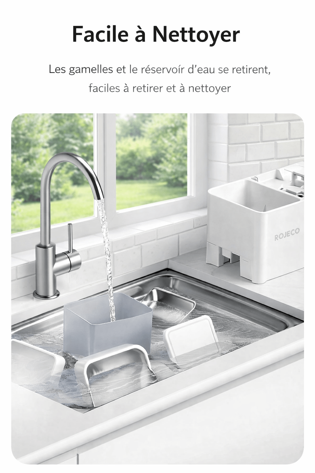 Évier moderne avec vue sur jardin, montrant les pièces du distributeur ROJECO en train d'être nettoyées, gamelles et réservoir d'eau faciles à retirer et à laver.