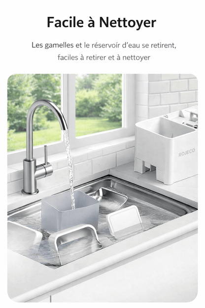 Évier moderne avec vue sur jardin, montrant les pièces du distributeur ROJECO en train d'être nettoyées, gamelles et réservoir d'eau faciles à retirer et à laver.