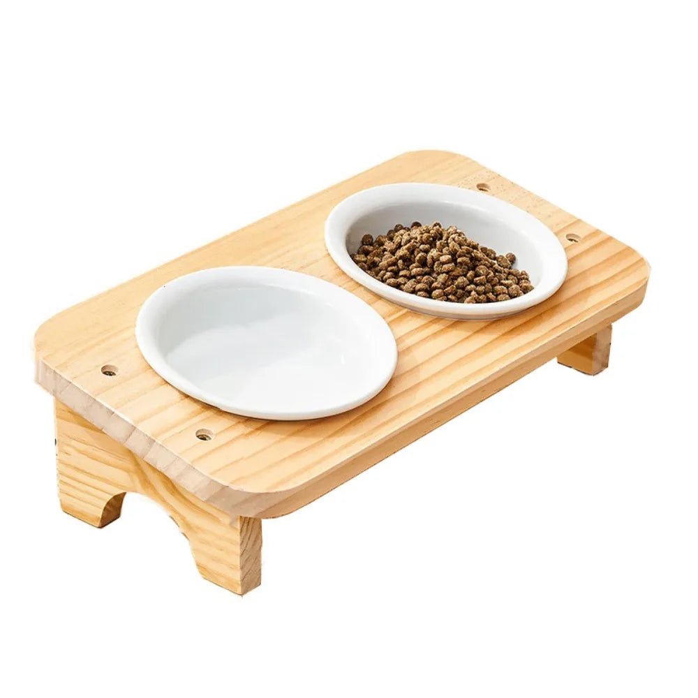 Gamelle chat inclinée 2 bols céramique blanche sur support bois naturel, configuration eau et croquettes, fond blanc