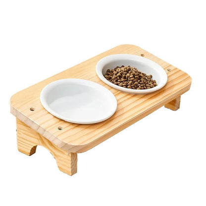 Gamelle chat inclinée 2 bols céramique blanche sur support bois naturel, configuration eau et croquettes, fond blanc