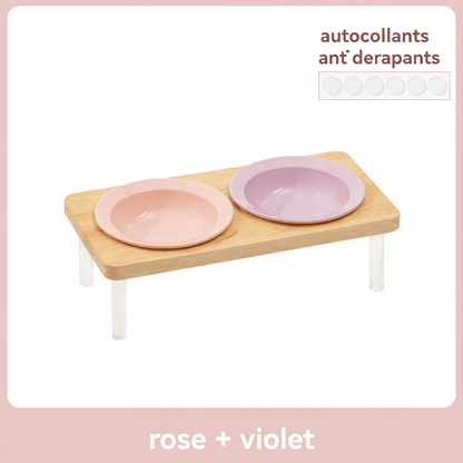 Gamelle surélevée pour chat MiaouTable, coloris rose et violet, avec support en bois et autocollants antidérapants.